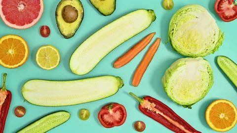Creative pattern with fruits and vegetables on cyan background. Stop motion Stock Footage 192469249