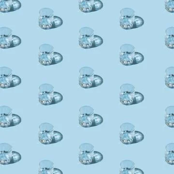 Creative pattern made with glass of vodka on blue pastel backdrop. Minimal pa Stock Photos