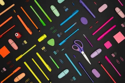 Creative pattern made of neon colorful stationery set on black background. Stock Photos