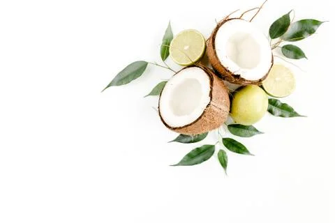 Creative pattern made of summer tropical fruits: coconut, lime and leaves ficus Stock Photos