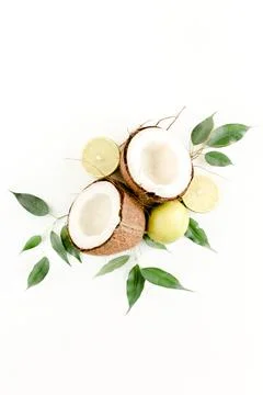 Creative pattern made of summer tropical fruits: coconut, lime and leaves ficus Stock Photos