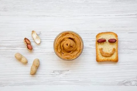 Creative pattern made of toast, peanut butter and peanuts in shells, top view Foto stock