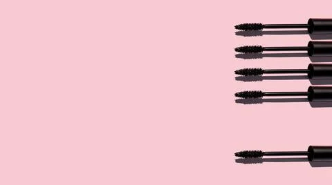 Creative pattern of mascara brushes on pink background. Make up products. Copy Stock Photos