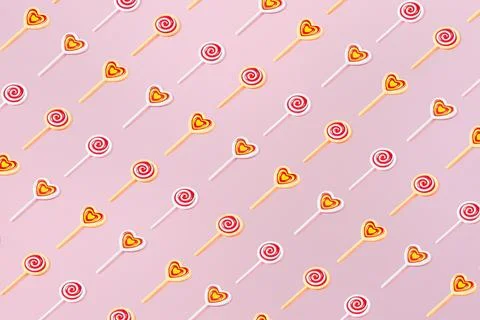 Creative pattern with round heart lollipops flat lay on pastel pink backgroun Stock Photos