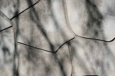 Creative patterns emerge on textured wall in shadowy sunlight Stock Photos