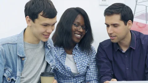 Creative people laughing while discussing presentation on laptop Stock Footage 105190079