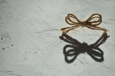 Creative photo of a bow from a string on a gray background with a hard light Stock Photos