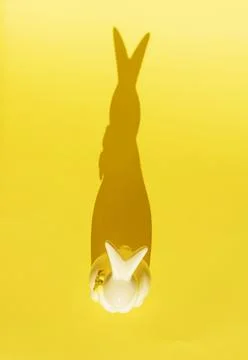 Creative photo. Ceramic Easter bunny on a yellow monochrome background, the Stock Photos