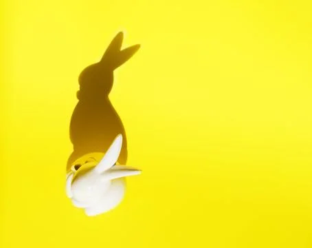 Creative photo. Ceramic Easter bunny on a yellow monochrome background, the Stock Photos