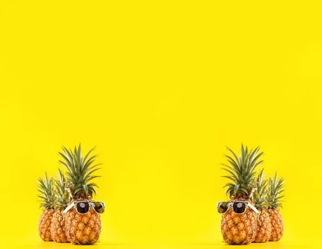 Creative pineapple looking up with sunglasses and shell isolated on yellow ba Stock-Fotos