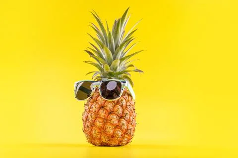 Creative pineapples with sunglasses isolated on yellow background, summer v.. Stock Photos