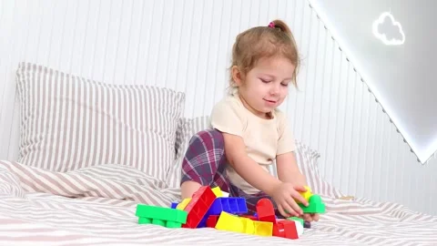 Creative playtime with colorful building blocks on a cozy bed Stock-Footage 295350684