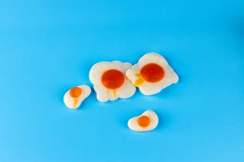 Creative Presentation of Colorful Fried Eggs on a Bright Blue Background Stock Photos