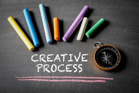 CREATIVE PROCESS. Compass and colored pieces of chalk on a blackboard Stock Photos