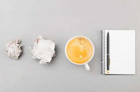 Creative process creative process. crumpled wads, notebook and cup on gray... Fotos de archivo