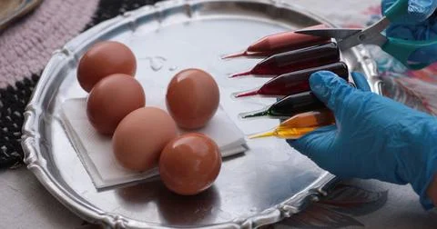 Creative process of decorating easter eggs with vibrant paints and tools fo.. Stock Photos