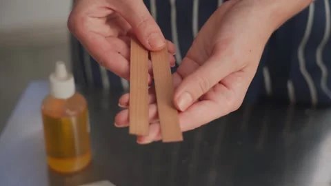 The creative process of making wax scented candles. Female hands hold wooden Vidéo 269403432