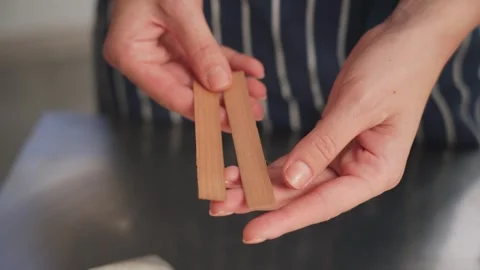 The creative process of making wax scented candles. Female hands hold wooden Vídeos de archivo 269404183