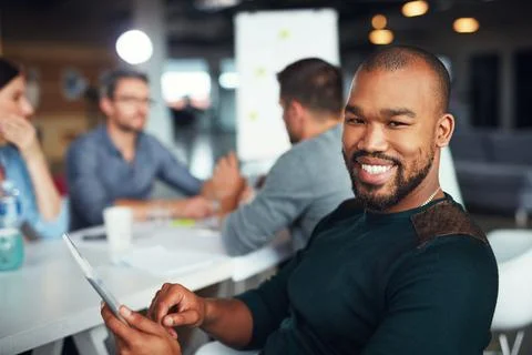 The creative process. Portrait of a man sitting at a table in an office using 写真素材