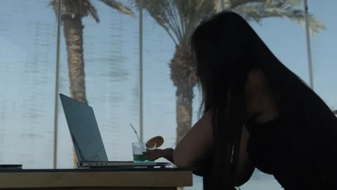 A creative professional opening a laptop and starting focused work in a tropical Stock Footage 346250548
