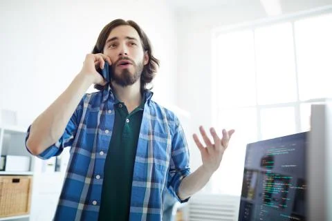 Creative programmer talking to customer on phone Stock Photos