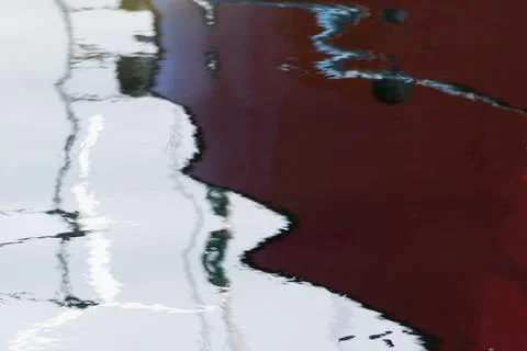 Creative reflection of boat and flags in the water. Abstract natural art Stock Photos