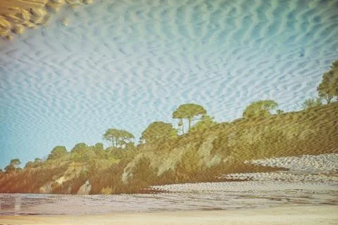 Creative reflection of seaside landscape with rocks ,trees and blue sky in st Foto stock
