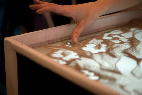 Creative Sand Art Table With Hand Drawing Soft Patterns In Warm Light Scene Foto stock