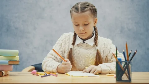 Creative schoolkid drawing, then putting one of the pencils back into the box. Stock Footage 113070466