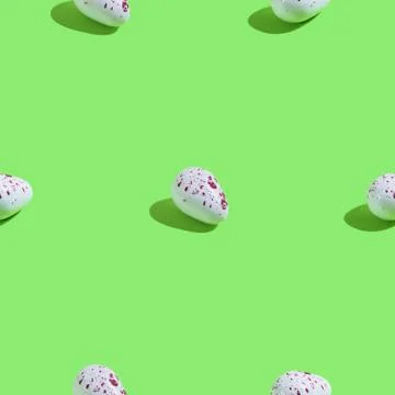 Creative seamless pattern with easter quail eggs on green background. Abstrac Stock Photos