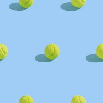 Creative seamless pattern with green tennis ball on light blue background. Sw Stock Photos