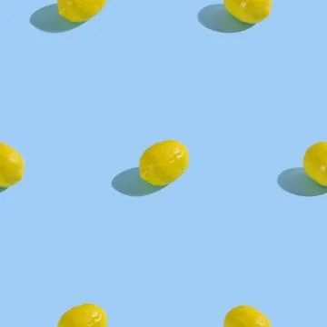 Creative seamless pattern with lemon on light blue background. Tropical abstr Stock Photos