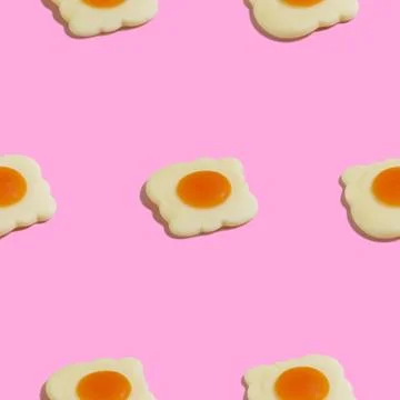 Creative seamless pattern with scrambled eggs on pink background. Food abstra Stock Photos