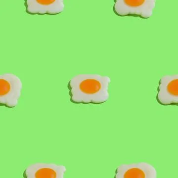 Creative seamless pattern with scrambled eggs on green background. Food abstr Stock Photos