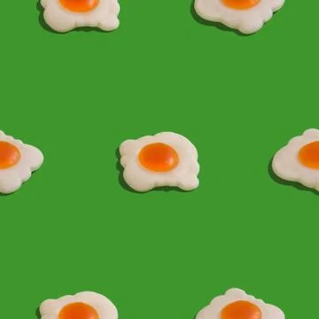 Creative seamless pattern with scrambled eggs on green background. Food abstr Stock Photos