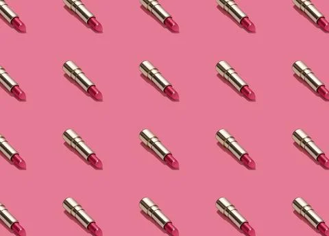Creative seamless pattern of vivid pink golden lipsticks on bright pink Stock Photos