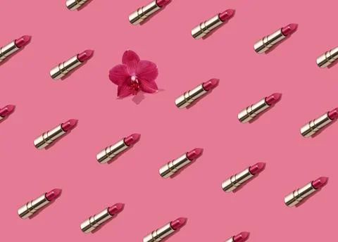 Creative seamless pattern of vivid pink golden lipsticks and orchid flower on Stock Photos