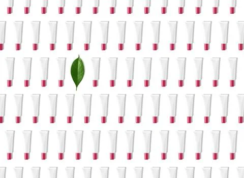 Creative seamless pattern of white and pink cosmetic tubes and green leaf on Foto stock