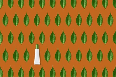 Creative seamless pattern of white cosmetic tube and green leaves on orange Stock Illustration