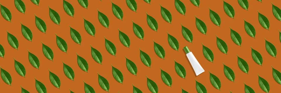 Creative seamless pattern of white cosmetic tube and green leaves on orange Stock Illustration
