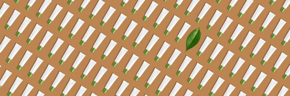 Creative seamless pattern of white cosmetic tubes and green leaf on sand colored Stock Illustration