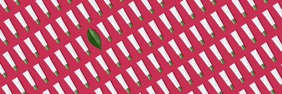 Creative seamless pattern of white cosmetic tubes and green leaf. Toned image in Stock Photos