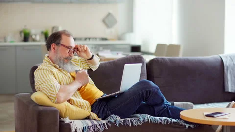 Creative senior man working on laptop over tea Stock Footage 153873111