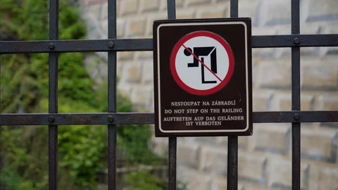 Creative sign prohibiting climbing over fence. Sketchy man hangs on railing 库存影片 129338986
