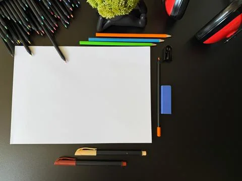 Creative space: table with school supplies and red headphones to relax. Stock Photos
