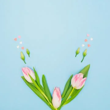 Creative spring composition with green leaves, pink hearts, rosebuds and past Stock Photos