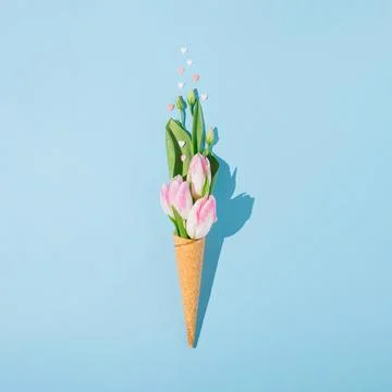 Creative spring flat lay with ice cream cone, green leaves, pink hearts and p Foto stock
