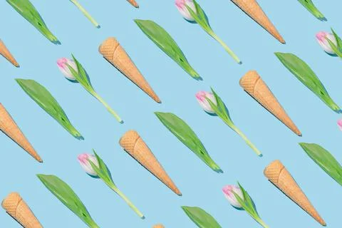 Creative spring pattern made with ice cream cones, pink tulips and green leav Stock Photos