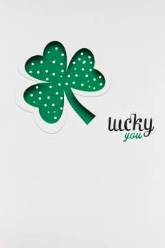 Creative St. Patricks Day concept photo of a shamrock made of paper on white bac Stock Photos
