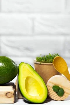 Creative still life with avocado, micro green and spoon on white background w Stock Photos